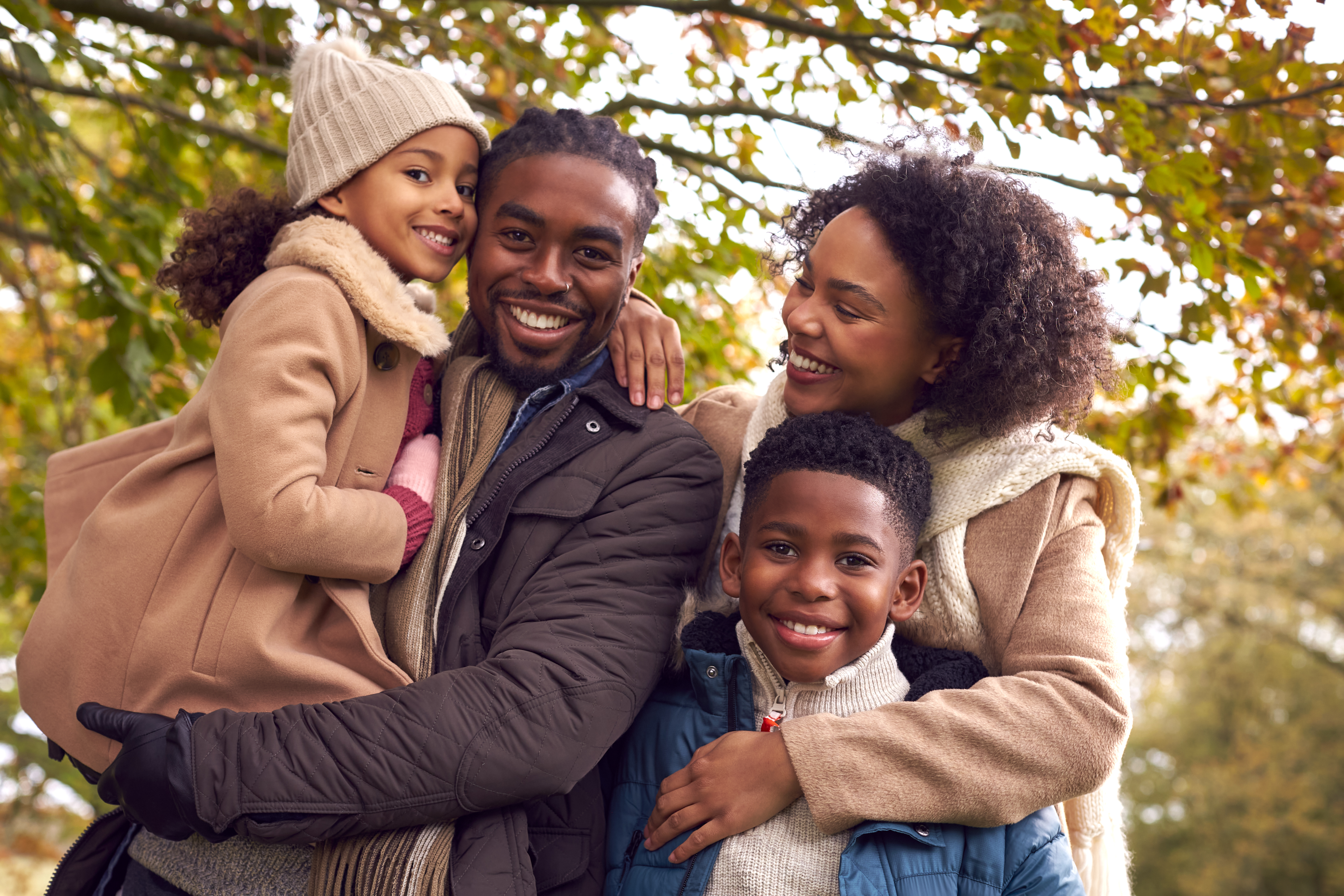 Portrait Of Smiling Family On Walk Through Countryside Against Autumn Trees
